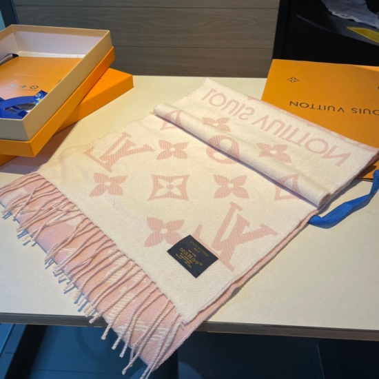 On May 5th, 2023, the most popular pink and white scarf of the year, this LVEssential scarf focuses on major elements, showcasing the brand's heritage with a Monogram pattern and Louis Vuitton logo, paired with soft tassel trim, making it a casual choice 